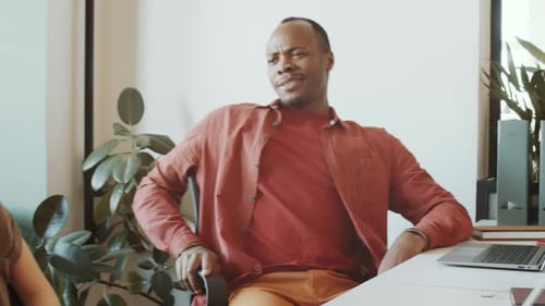 Cheerful Black Man Chatting with Female Caucasian Colleague in Office