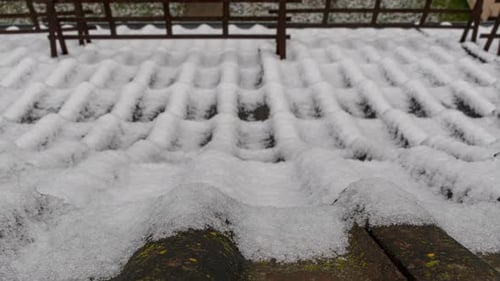 Snow Melting on Roof Tiles in Winter