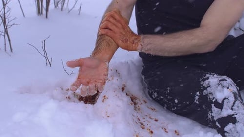 Un homme blessé au bras frissonnant de froid.