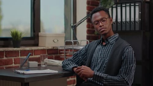 Smiling Young Man Talking at Office Desk