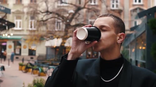 Young Adult Enjoying Coffee in Outdoor Cafe