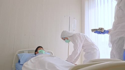 Patient receiving treatment by healthcare workers in hospital