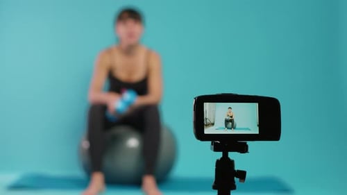 Entrenador filmando Vídeo entrenamiento en cámara para dar consejos sobre acondicionamiento físico