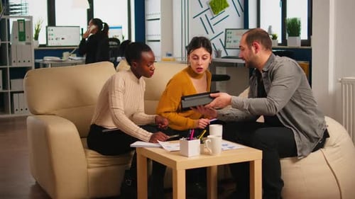 Équipe multiethnique analysant les informations de la tablette