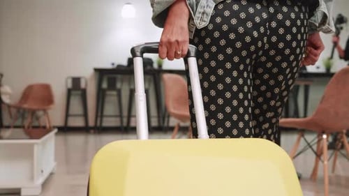 Hand of Female passenger dragging luggage or suitcase, walking to passenger terminal in airport