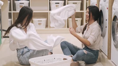 Two Happy Girlfriends Having Fun Together While Washing Selfservice Laundry
