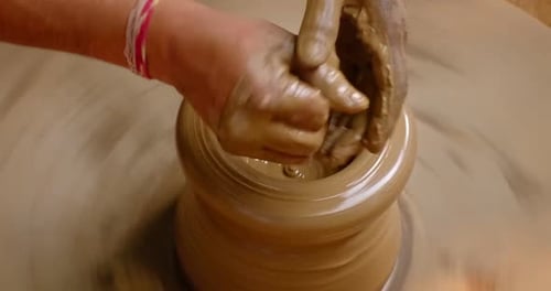 Des mains habiles de potier façonnent l'argile sur Potter Wheel et sculptent un pot en argile. Shipagramme