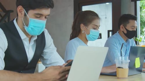 neues normales Lifestyle-Konzept Geschäftsleute mit Maske sitzen beim Arbeiten mit sozialer Distanzierung