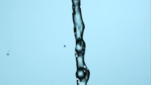 Clear Water Streaming and Bubbles against Blue Background