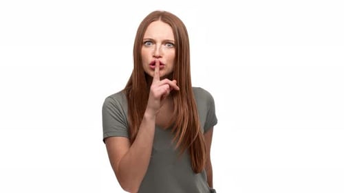 Porträt einer seriösen Ingwerfrau der 20er Jahre, die den Zeigefinger auf den Lippen hält und darum bittet, isoliert zu schweigen