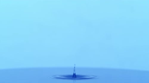 Water Drop Creates Ripples in Blue Pool