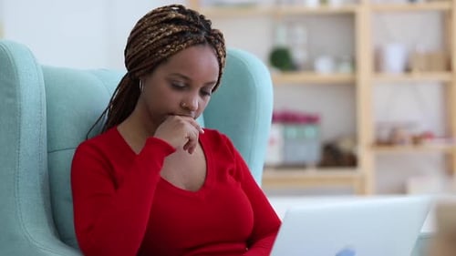Young Woman Works Remotely and Uses Laptop While Sitting in Chair at Apartment Room Spbi