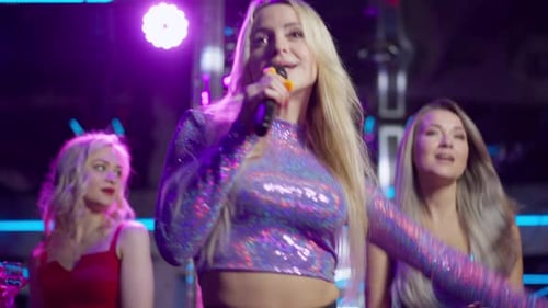 Woman Singing into Microphone in Night Club