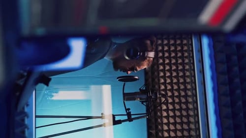 Male Rap Singer with Headphones and Sound Engineer are Recording a New Song