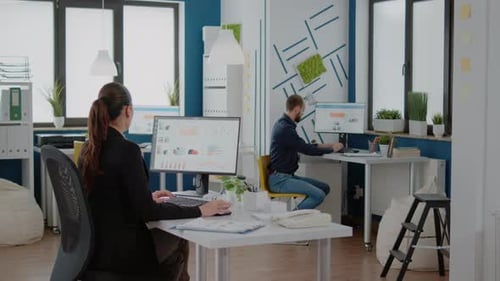 Woman with Corporate Job Using Computer with Data Charts