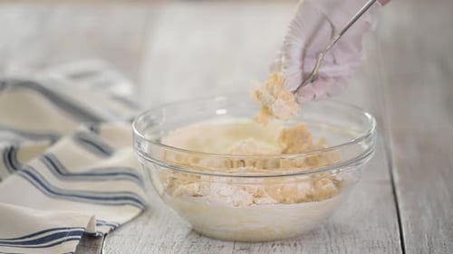 Hands Mixing Dough in Bowl with Spoon