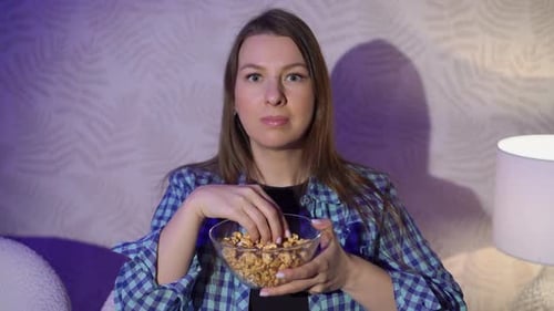 Woman Eats Caramel Corn Watching TV at Night