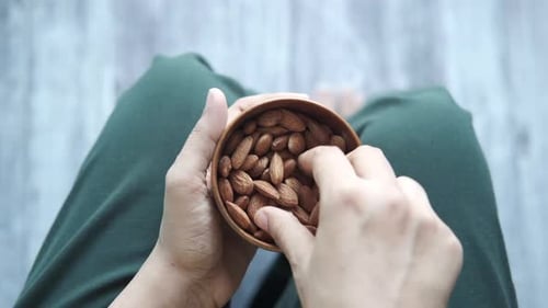 Top View of Women Hand Holding a Bowl on Almond