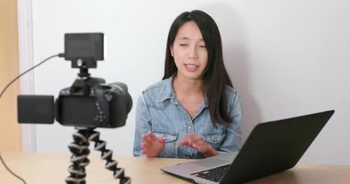 Woman Filming Video with Camera and Laptop