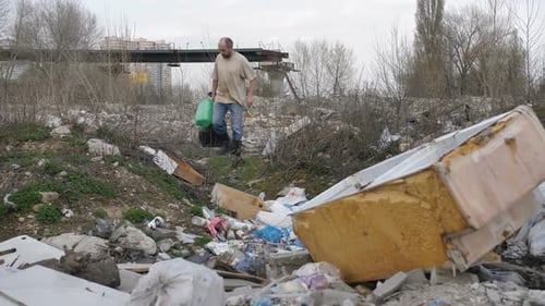 Man Walks Through Trash Dump in Urban Area