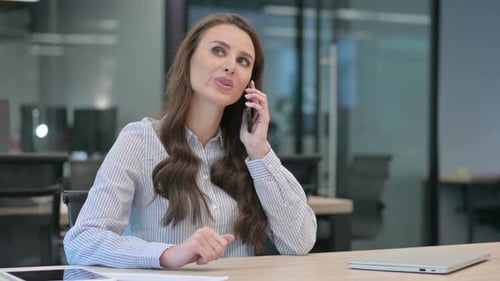 Young Woman Talking on Phone in Modern Office