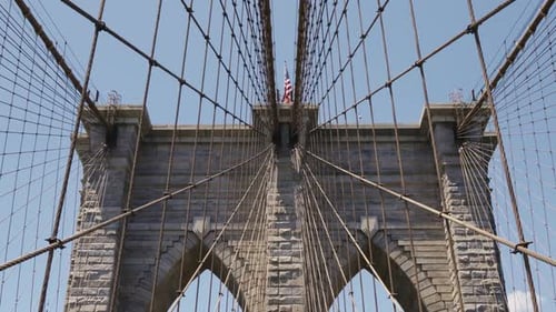 Iconic Brooklyn Bridge with American Flag on Sunny Day