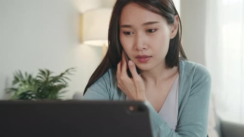 Woman Using Tablet While Talking on Phone