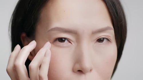 Woman Gently Touching Her Face Around Eye