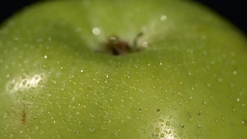 Oberseite von Wet Green Apple isoliert auf Schwarz, Rotation Nahaufnahme
