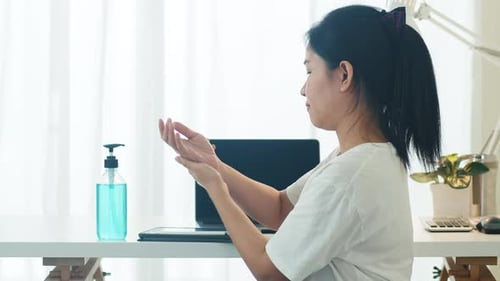 Asian woman using alcohol gel hand sanitizer wash hand before open tablet for protect coronavirus.