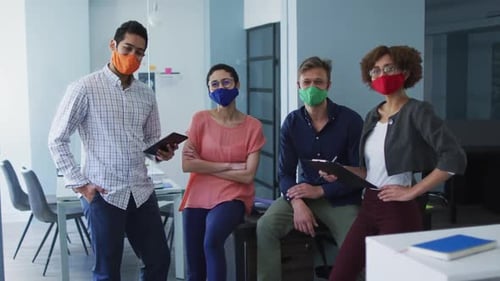 Portrait of diverse colleagues wearing face masks at modern office