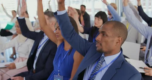Diverse Group Raising Hands in a Business Meeting