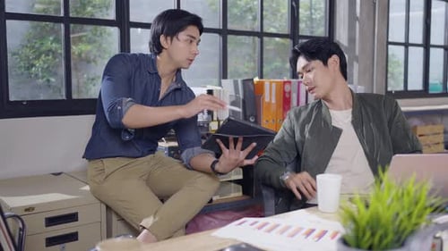 Young Adults Collaborating in Modern Office with Tablet