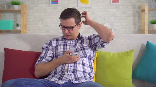 Man on Couch Using Mobile Phone