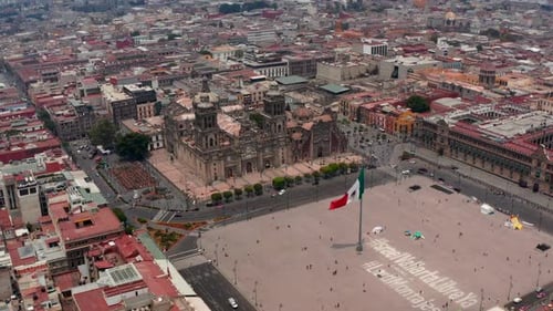 Stürme fliegen über die Plaza De La Constitucion mit großer Staatsflagge