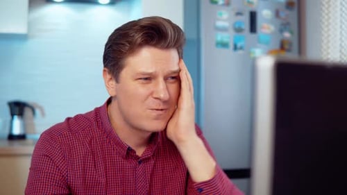 Man Looking at Computer With Shock and Dismay