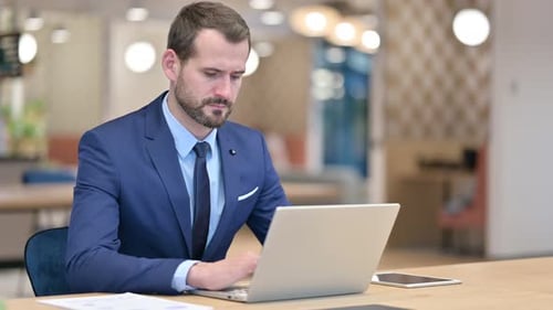 Businessman Working on Laptop in Office