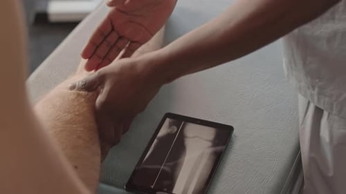 Physiotherapist Examining Shin Bone of Patient on Xray