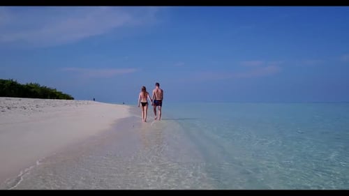 Romantic couple happy together on relaxing shore beach voyage by blue ocean and white sandy backgrou