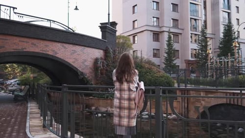 Attractive Brunette Girl Enjoys Walking Along the Street