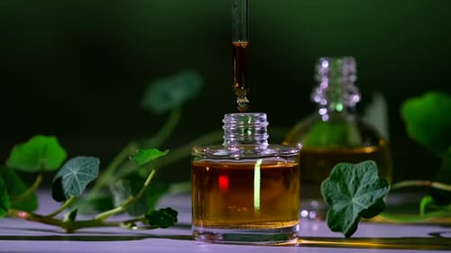 Produto de óleo essencial. Perfumaria. Gotas caindo da pipeta cosmética para o frasco de vidro com perfume