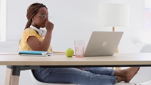 Woman Working at Home on Laptop with Headphones