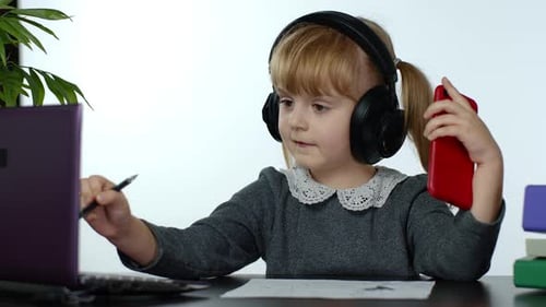 Child Learns Using Laptop and Smartphone