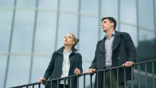 Young Adults Discuss Business Outside Modern Building