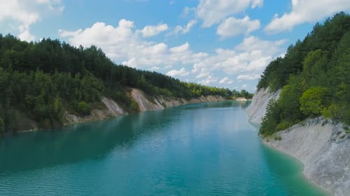Eine verlassene Gipsgrube mit blauem Wasser