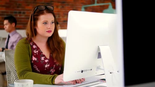 Young Woman Typing at Computer in Modern Office