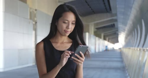 Woman Using Smartphone Device in Urban Setting