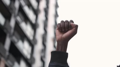 Raised Fist Against Urban Building