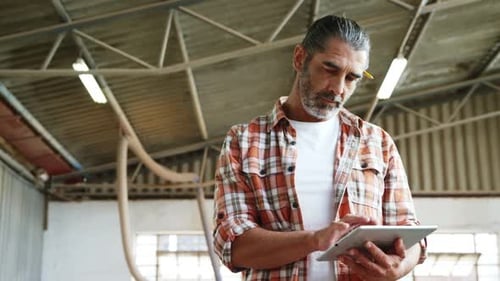 Man Using Tablet in Factory Setting