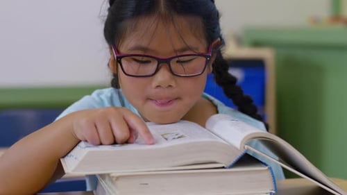 Girl reading book in school classroom